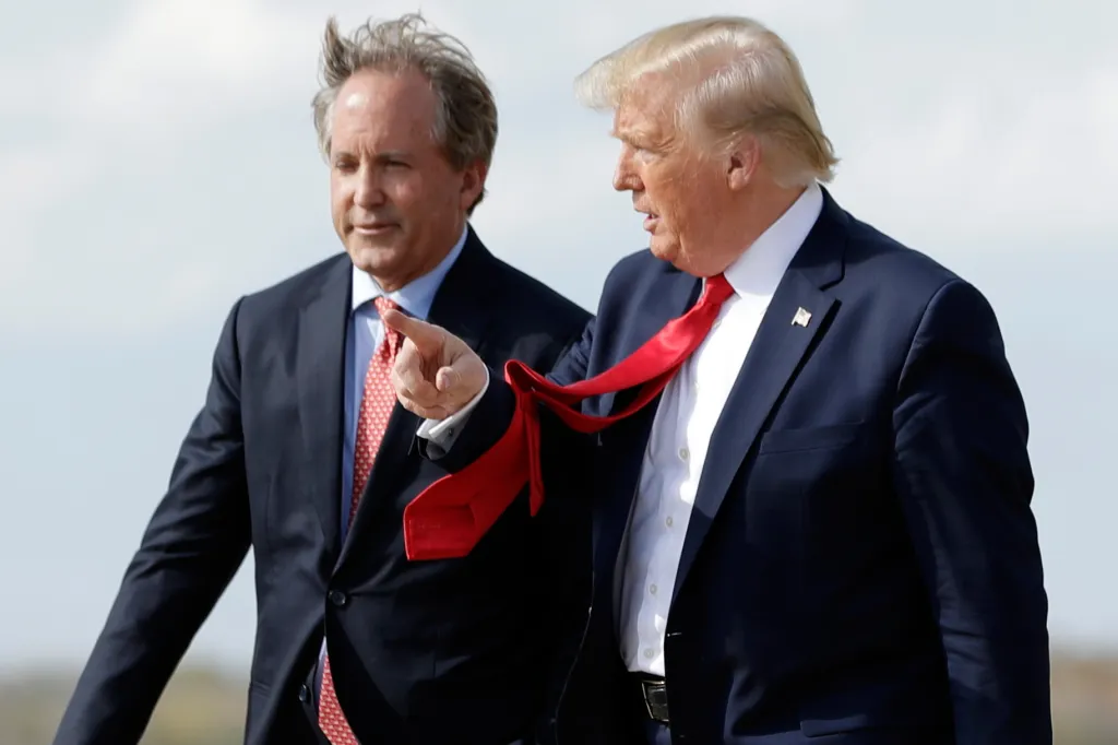 President Donald Trump points to his right while walking next to Texas Attorney General Ken Paxton.