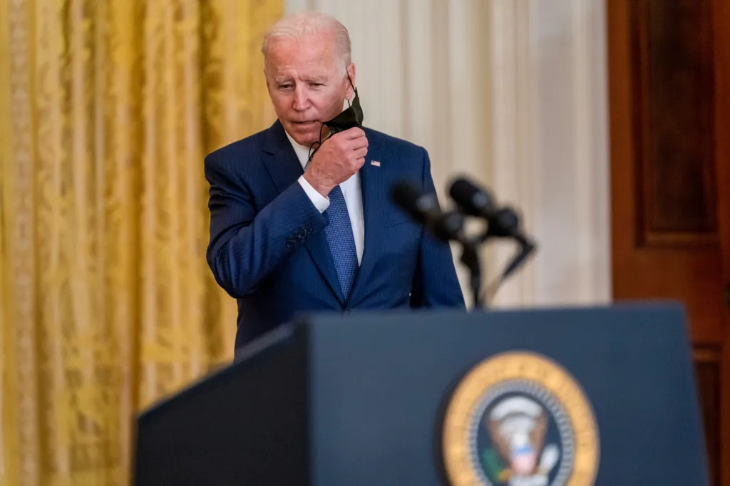 Former President Biden removes his mask before delivering remarks on the evacuation of American citizens and their families, SIV applicants and their families, and vulnerable Afghans from Afghanistan, in the East Room of the White House in Washington on Aug. 26, 2021.