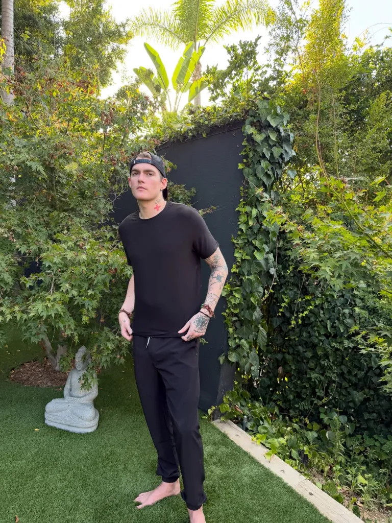 Presley Gerber standing barefoot in a garden.