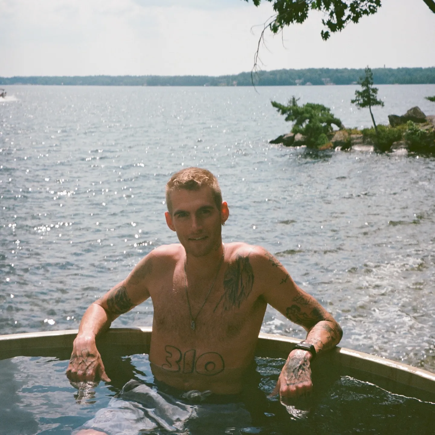 Presley Gerber, son of Cindy Crawford, relaxing in a hot tub by a lake.