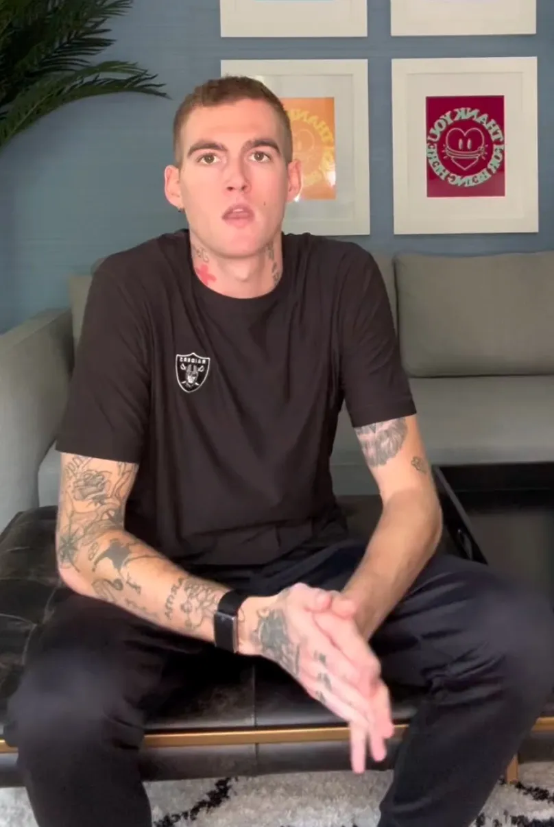 Presley Gerber seated on a bench, wearing a black shirt with the Raiders logo and black pants.
