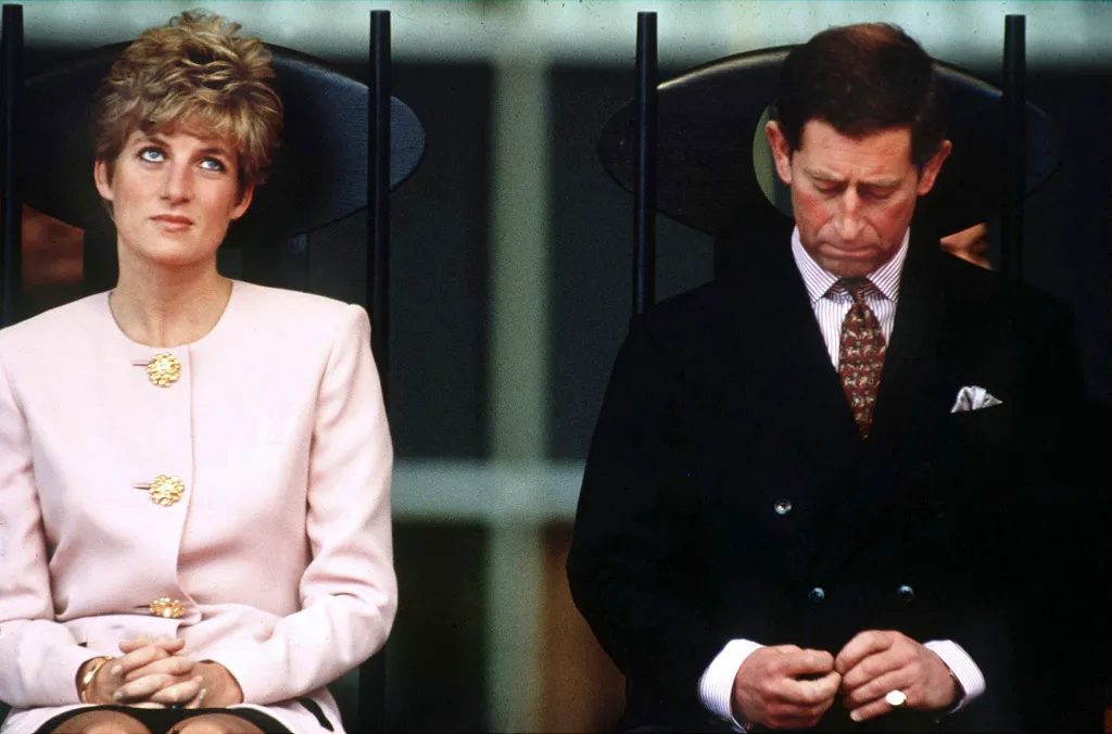 Princess Diana looking upwards while Prince Charles looks down during a royal tour.
