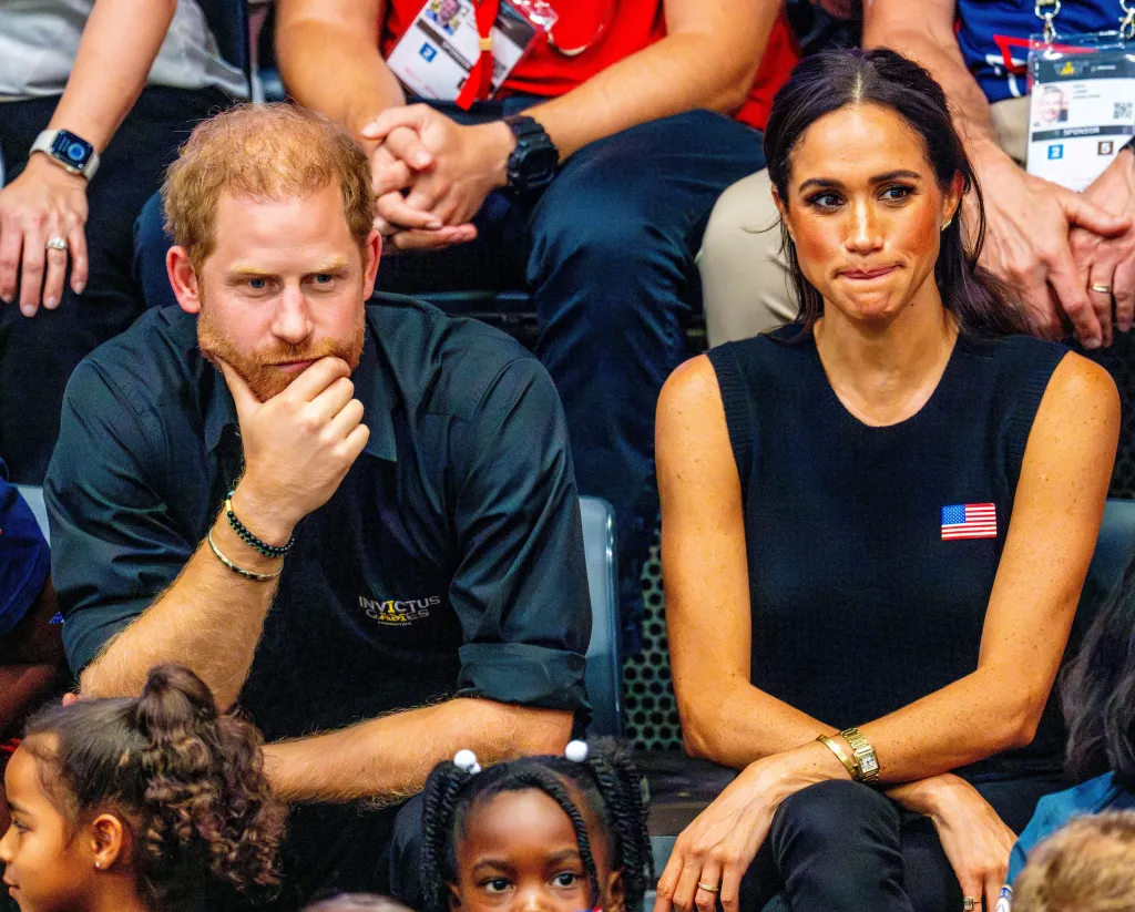 Prince Harry and Meghan Markle sitting together, looking forward.
