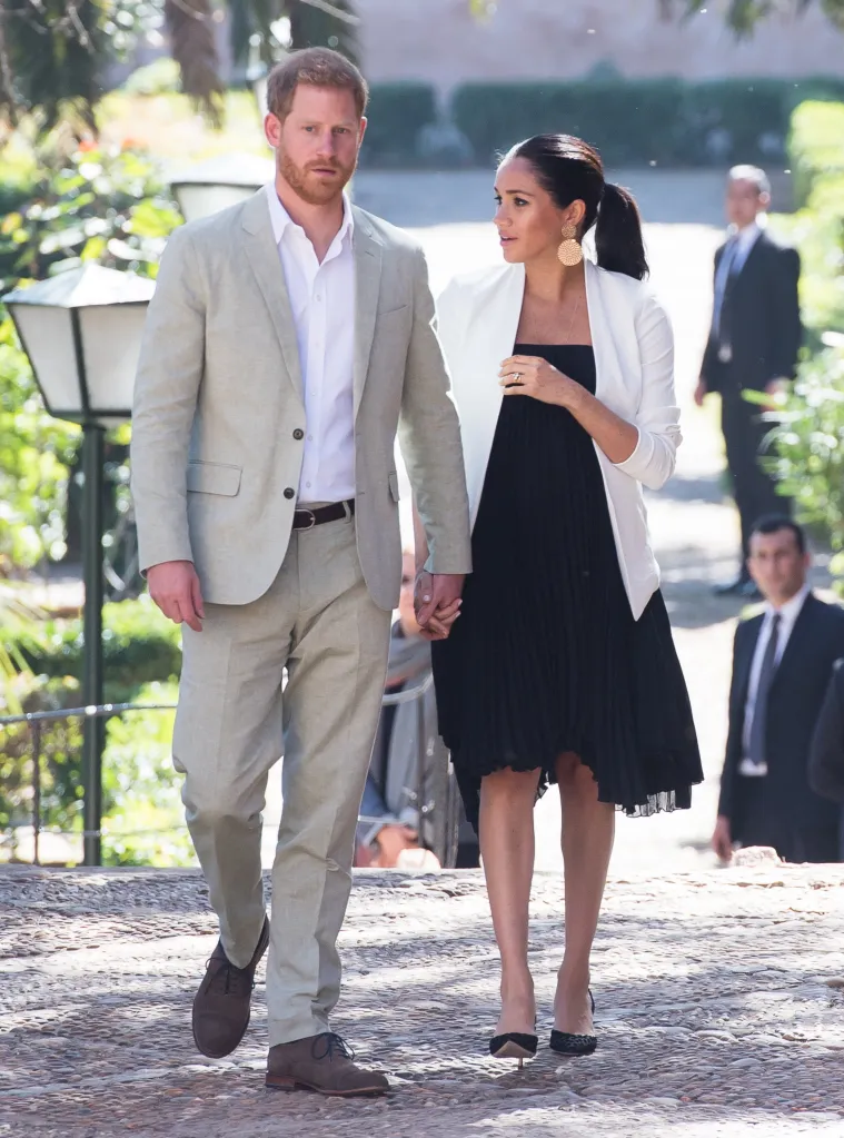 Prince Harry and Meghan Markle holding hands while walking in the Andalusian Gardens in Rabat, Morocco.
