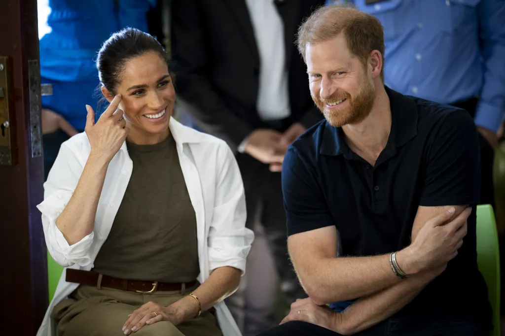 Meghan Markle and Prince Harry smiling during a visit to the QuestScope Youth Center in Jordan.