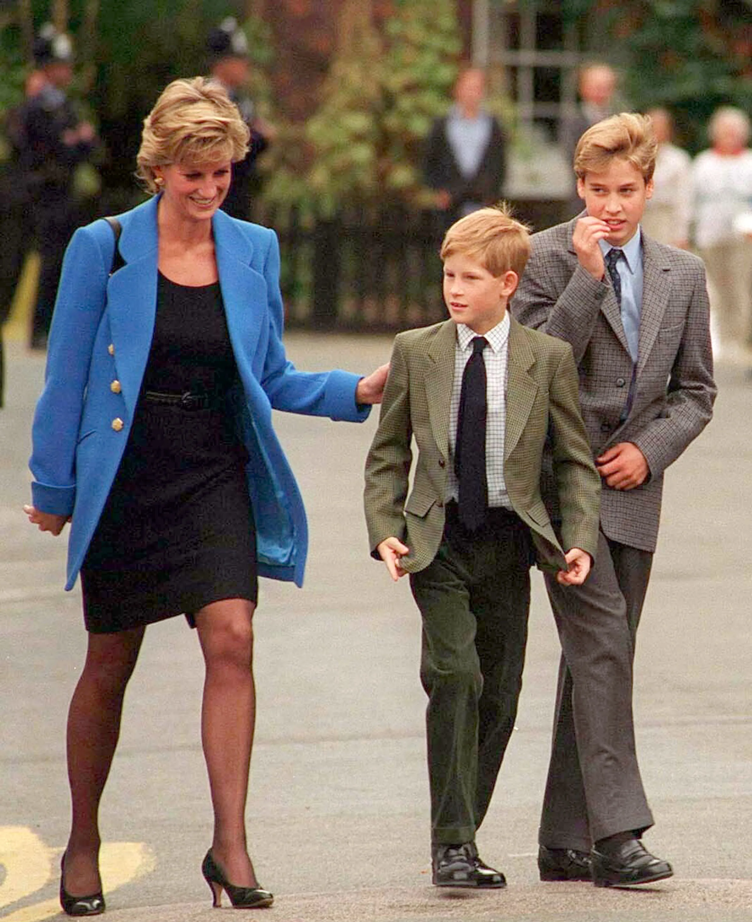 Princess Diana in a blue coat with her two sons, William and Harry, outside Eton College.