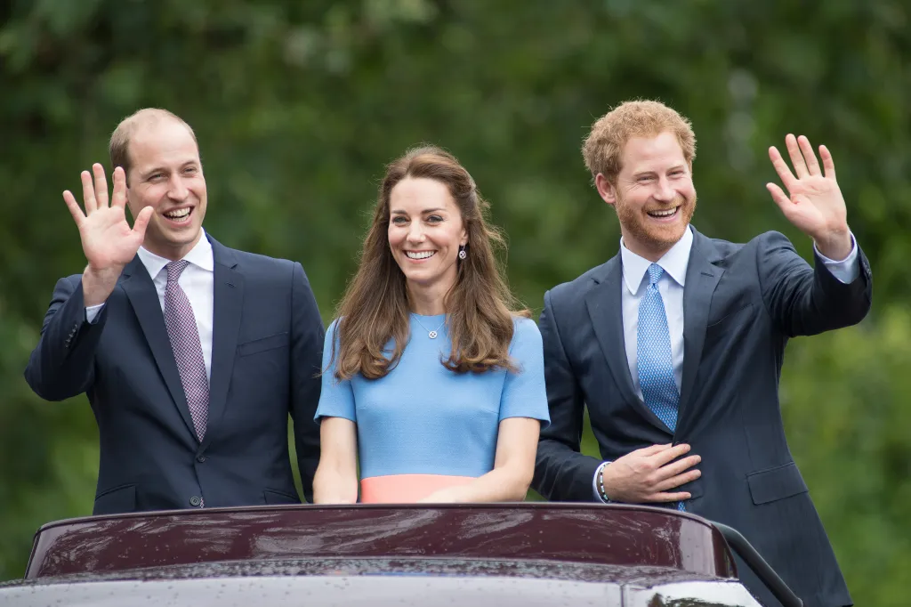 Prince William, Catherine, Duchess of Cambridge, and Prince Harry waving from a vehicle during The Patron's Lunch celebrations for The Queen's 90th birthday.