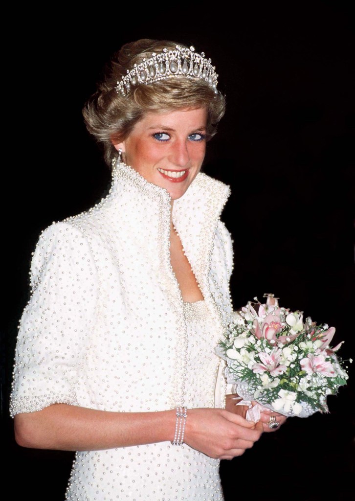 Diana, Princess of Wales, wearing a white pearl-embellished gown, tiara, and holding a bouquet of flowers.