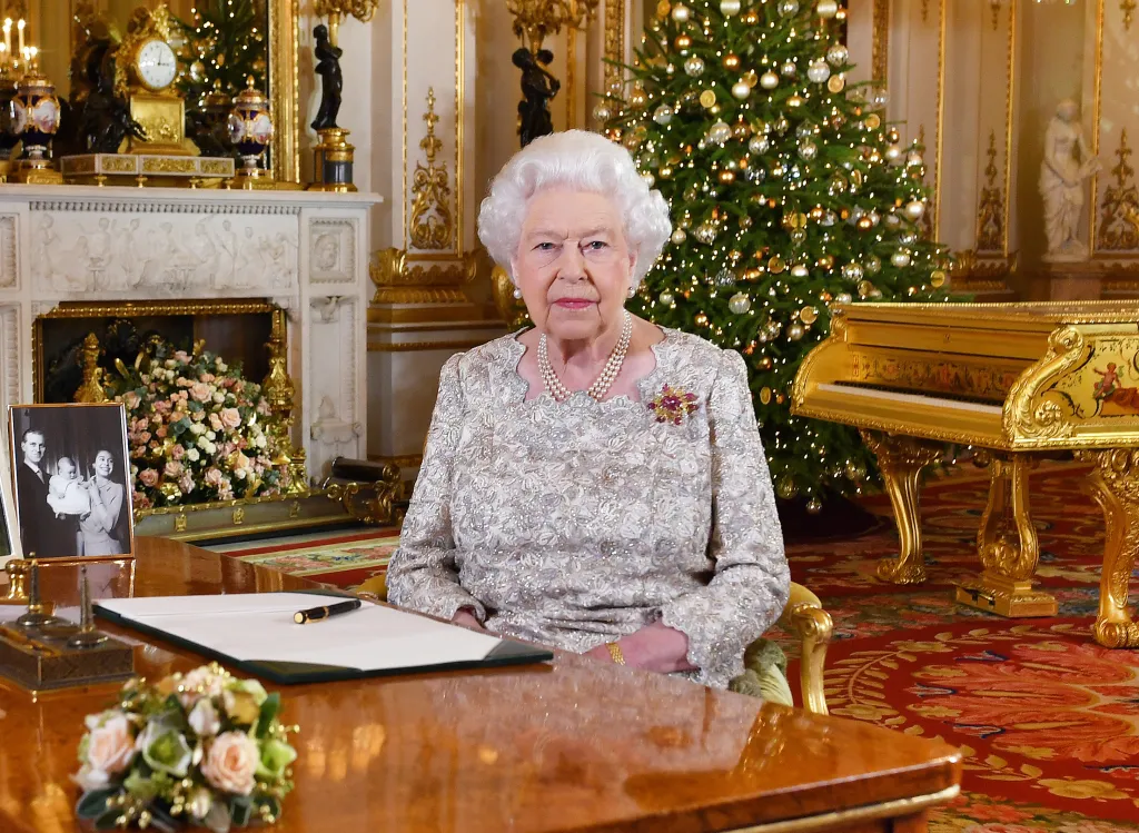 Queen Elizabeth II seated at a desk, delivering her annual Christmas Day message.