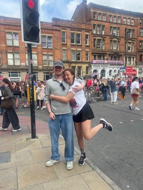 Rachel and Harry Ware embracing on a city street.