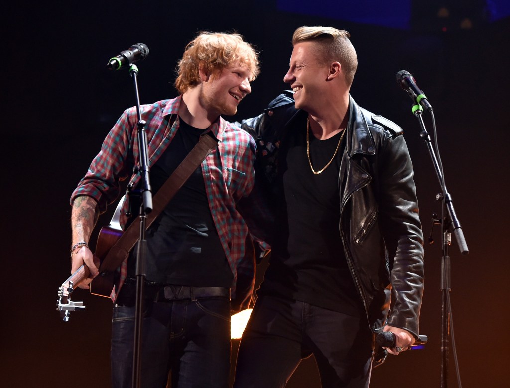 Recording artists Ed Sheeran and Macklemore perform on stage.
