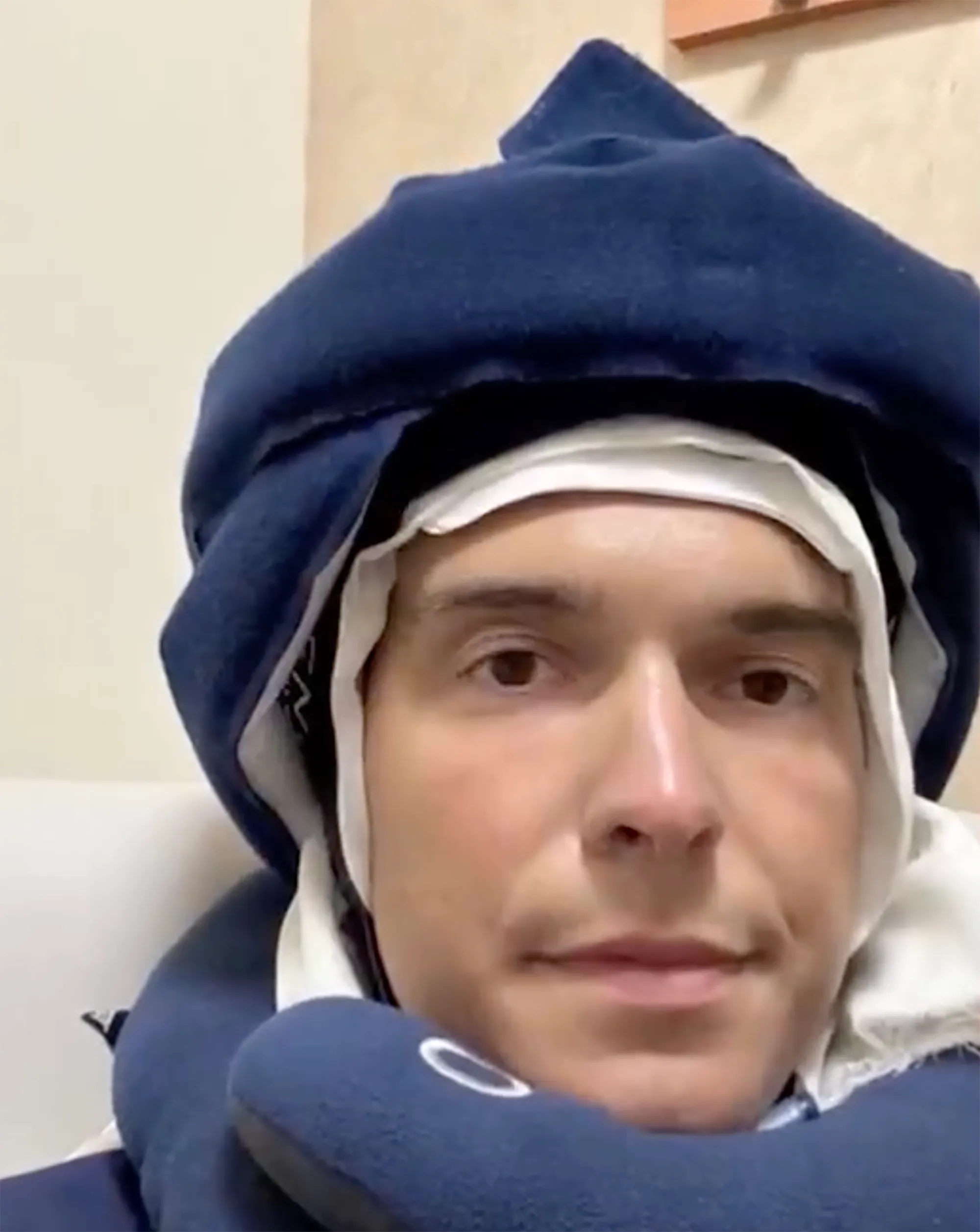 Will Reeve wearing a medical head wrap and neck pillow.
