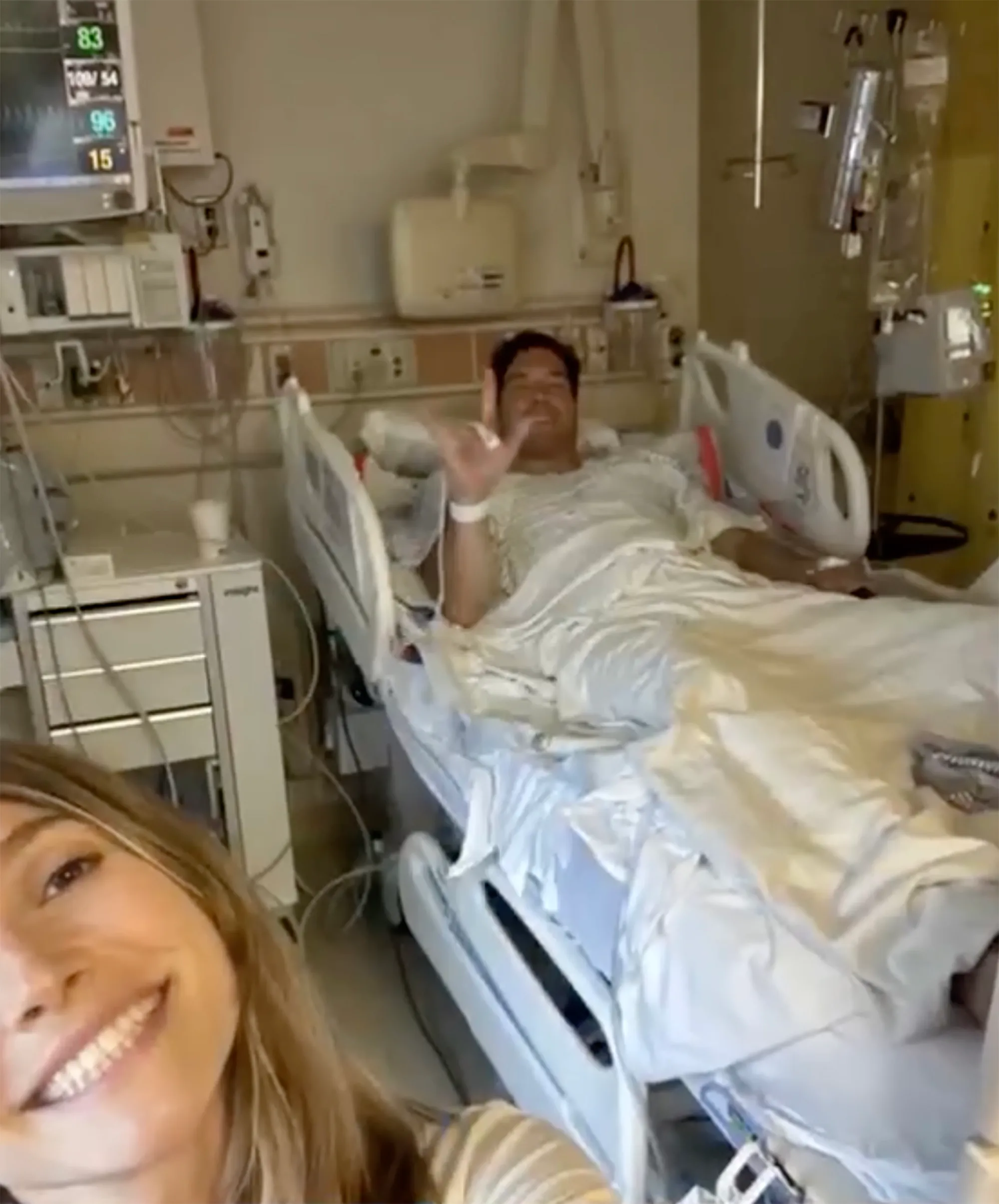 Will Reeve in a hospital bed with a woman smiling in the foreground.