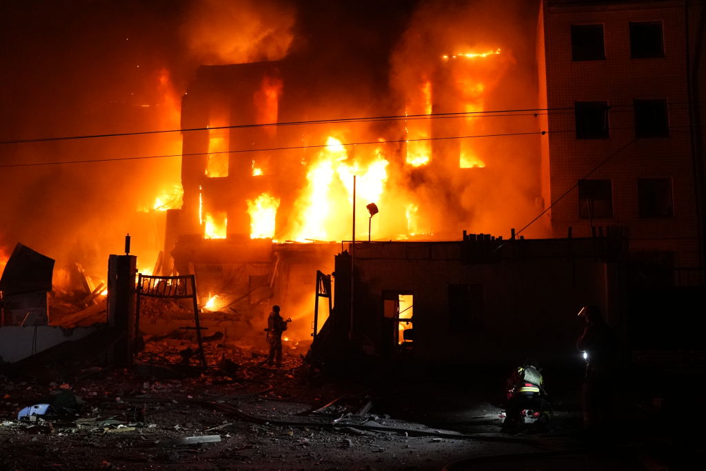 A rescue worker puts out a fire of a building destroyed after a Russian missile attack in Kyiv, Ukraine.