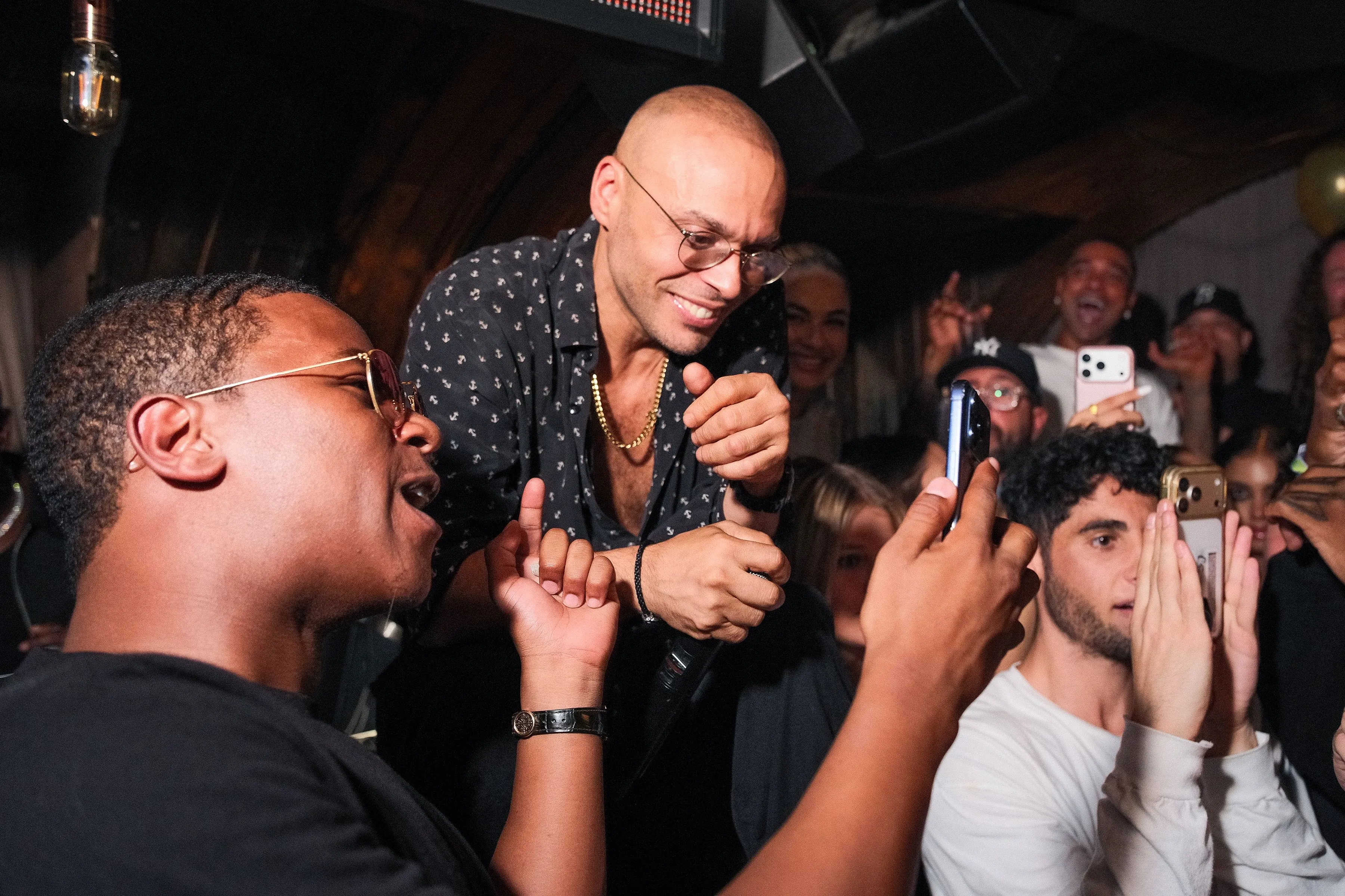 Nightclub owner Richie Akiva smiling with guests at his birthday celebration.