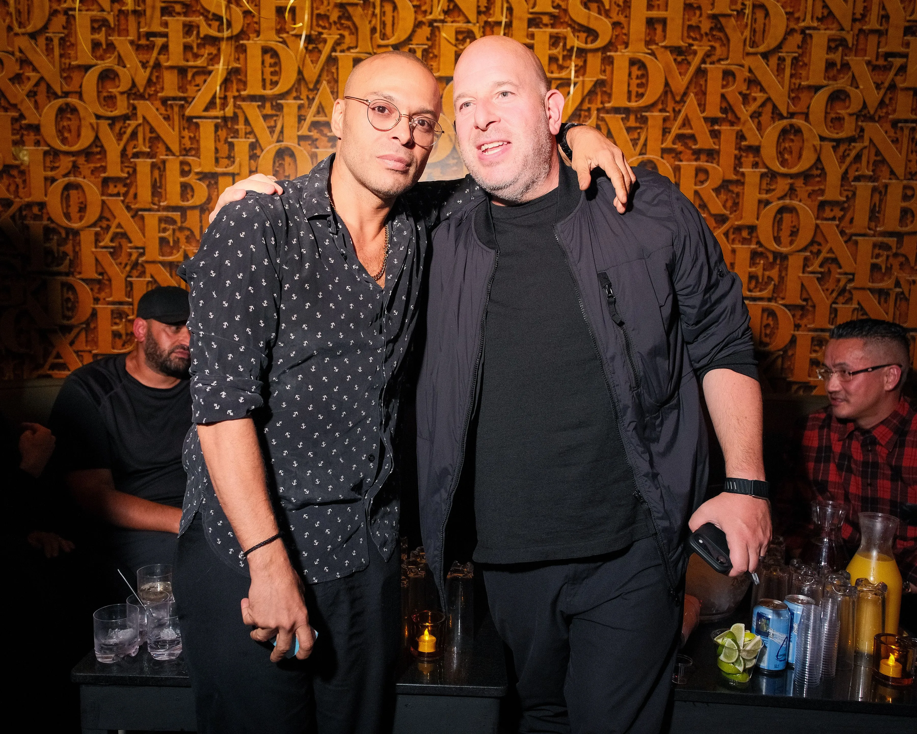 Noah Tepperberg and Richie Akiva smiling with arms around each other at a nightclub.