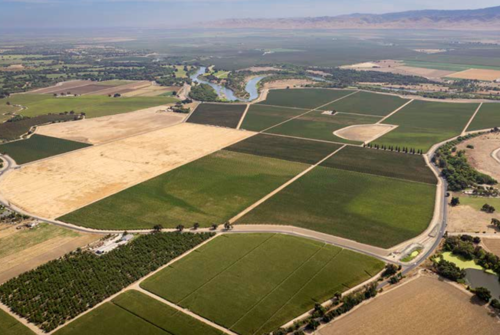 Aerial view of River Junction Vineyard with various crops and a winding river.
