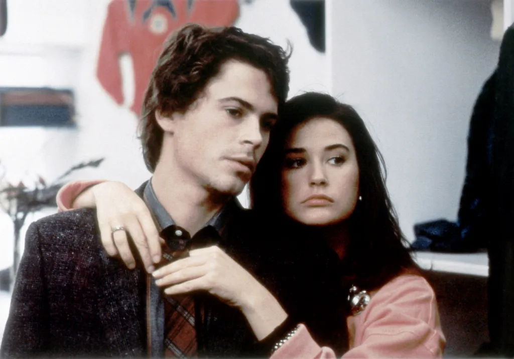 Rob Lowe with his arm around Demi Moore.