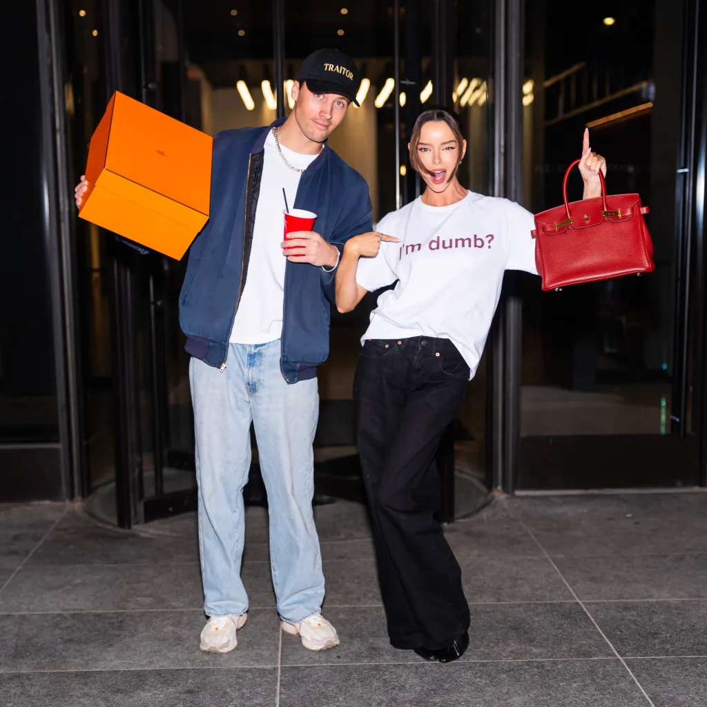 Rob Rausch holds an orange box and Maura Higgins points to her 