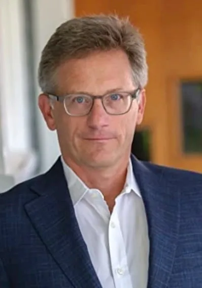 Rob Reich, professor of political science, in a headshot wearing glasses, a white collared shirt, and a blue suit jacket.