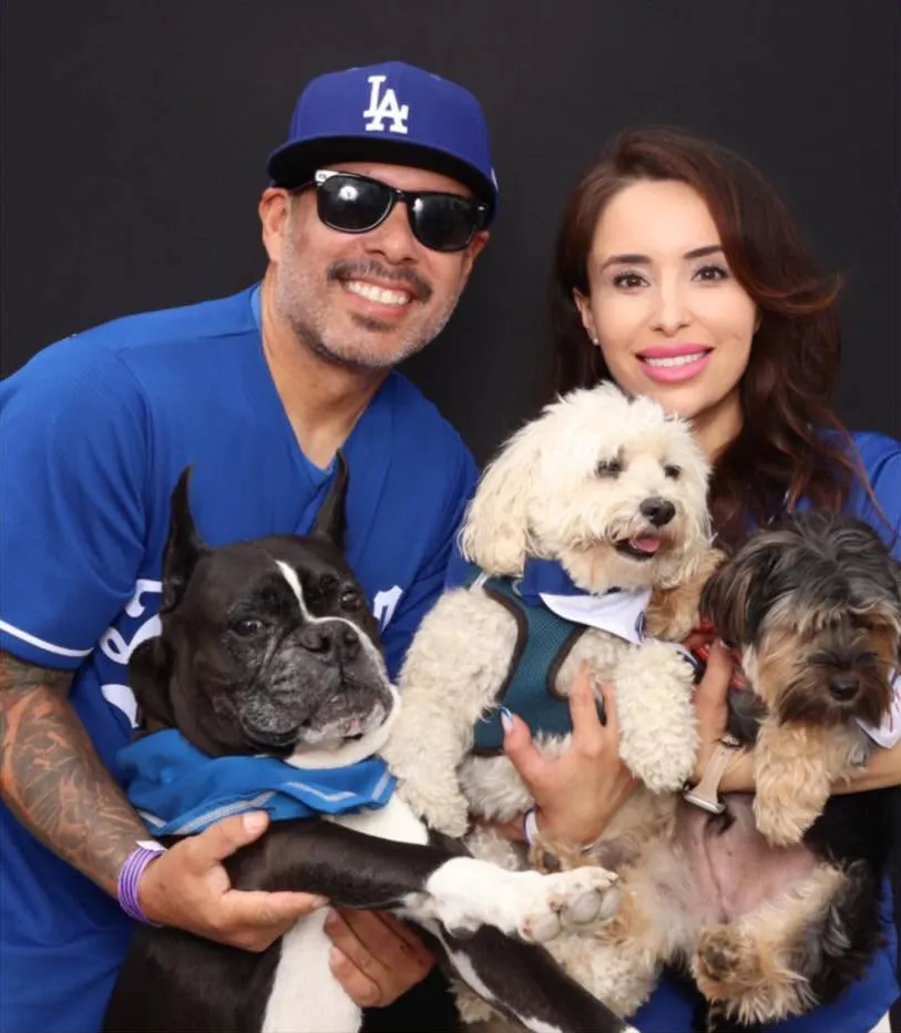 Robert Barrientos and Eliana Moreno posing with their three dogs.