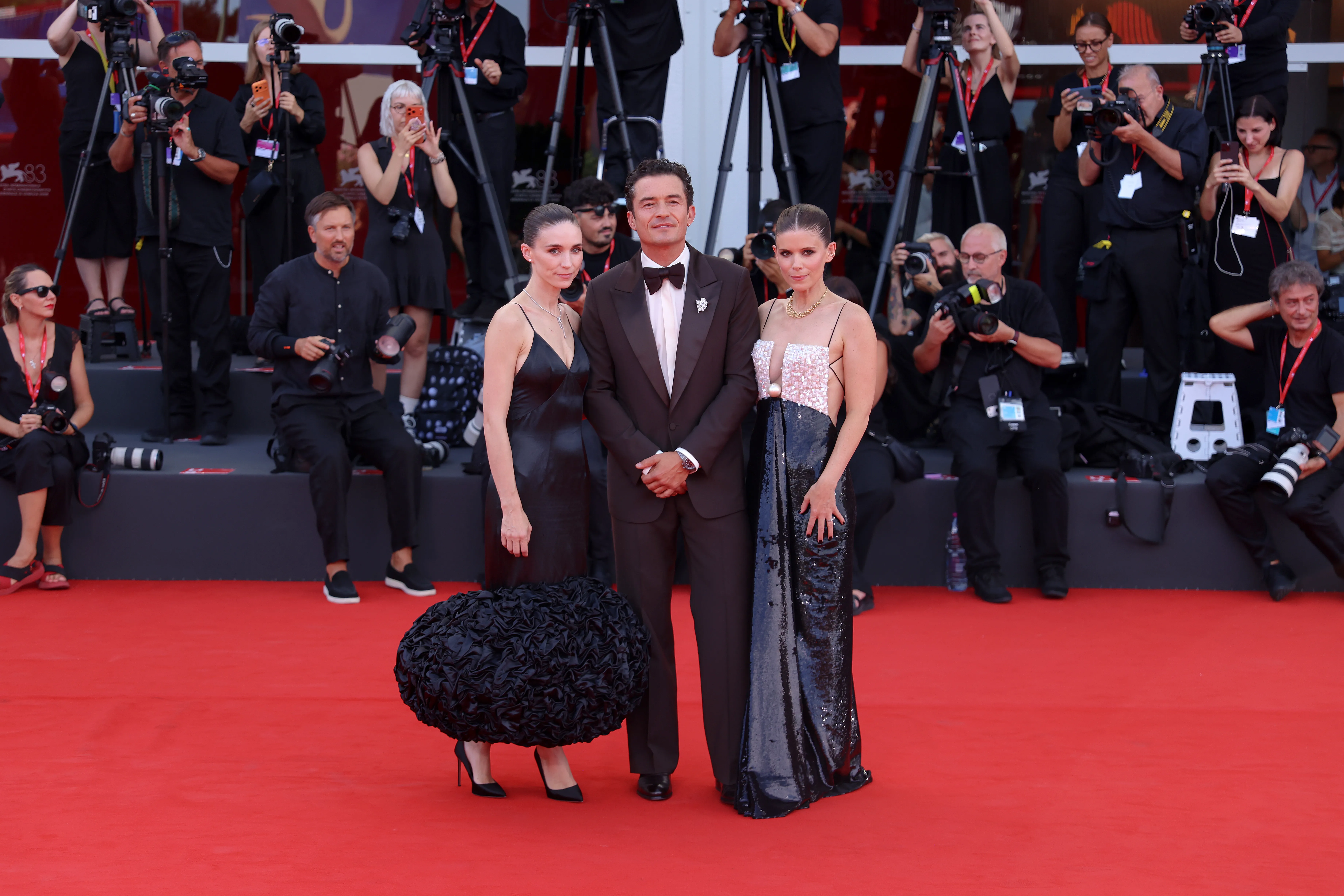 Rooney Mara, Orlando Bloom, and Kate Mara posing on a red carpet.