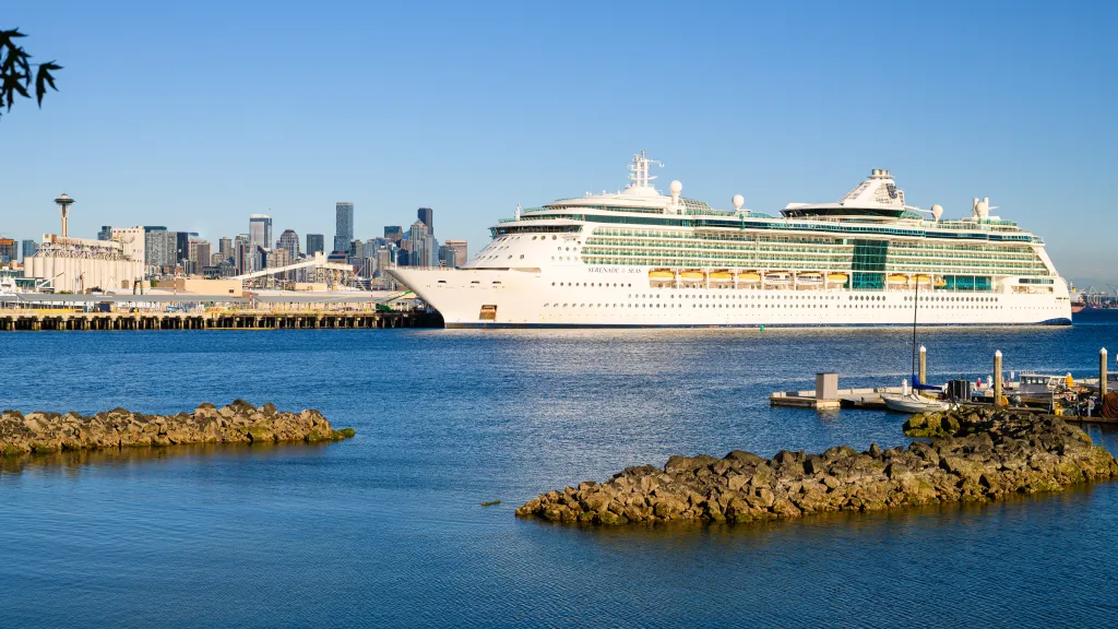 The Serenade of the Seas cruise ship docked in Seattle with the city skyline in the background.