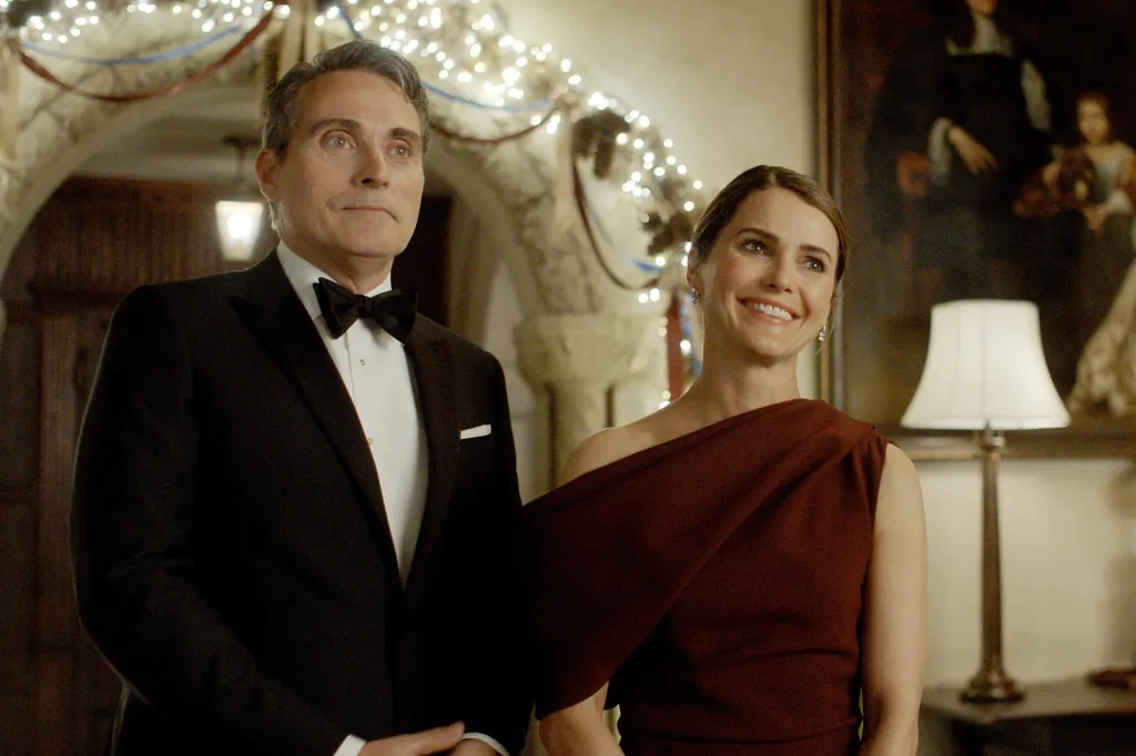 Rufus Sewell, in a black tuxedo, and Keri Russell, in an off the shoulder burgundy gown, in Season 3 of The Diplomat.