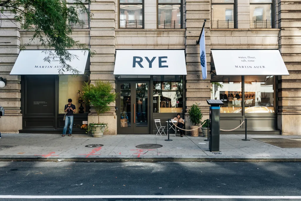 Exterior of the RYE by Martin Auer bakery in Nolita, Manhattan, with customers on the sidewalk.