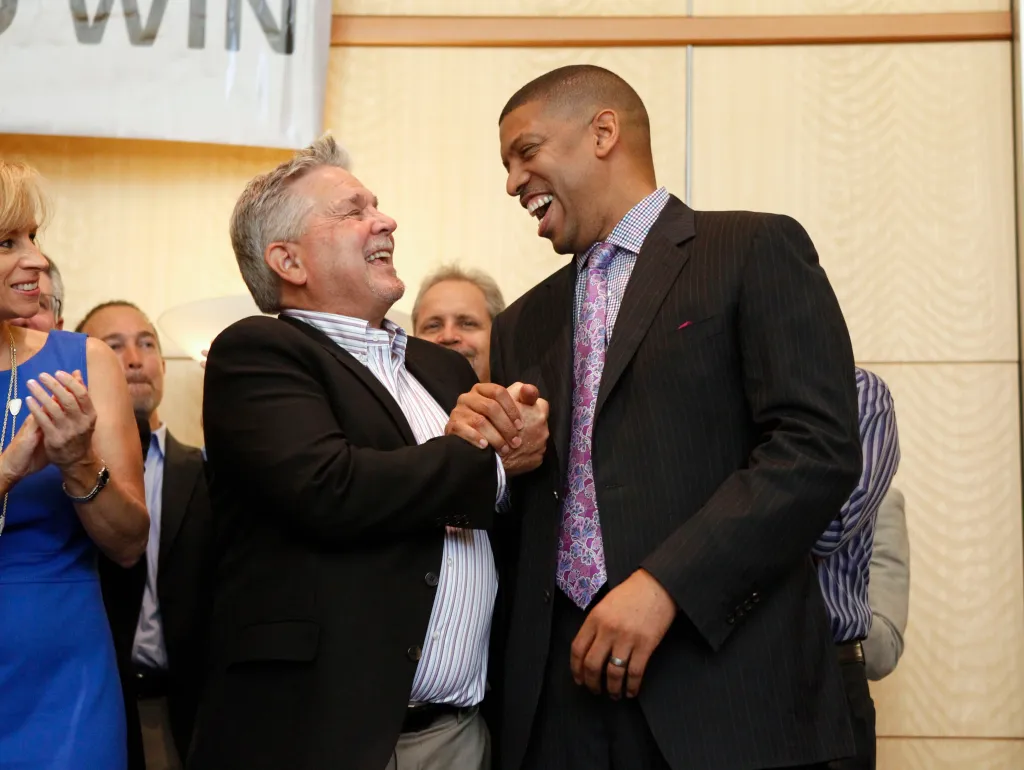 Sacramento Mayor Kevin Johnson shakes hands and laughs with investor Phil Oates during a rally.