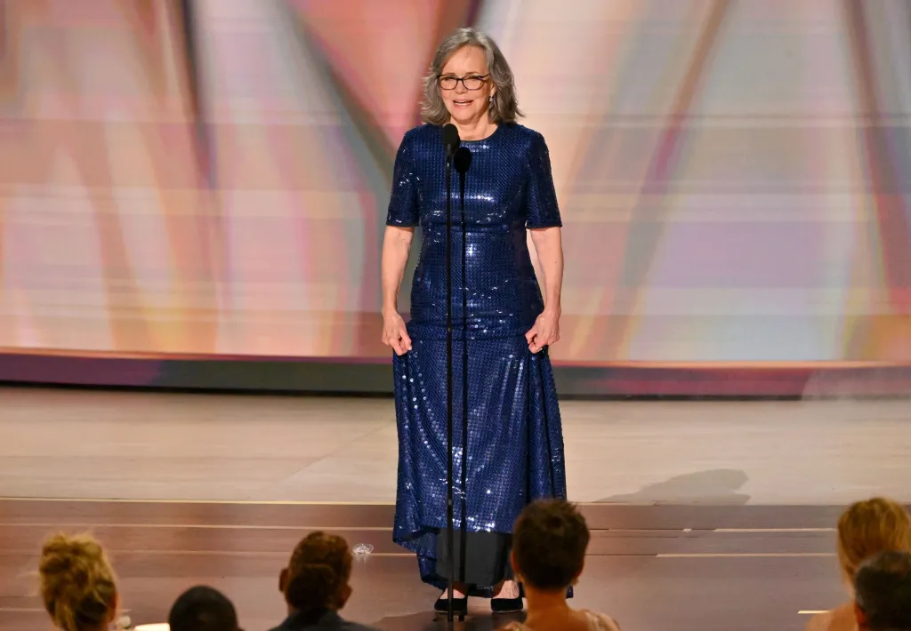 Sally Field speaks at the 78th Primetime Emmy Awards, wearing a sequined blue gown and glasses.