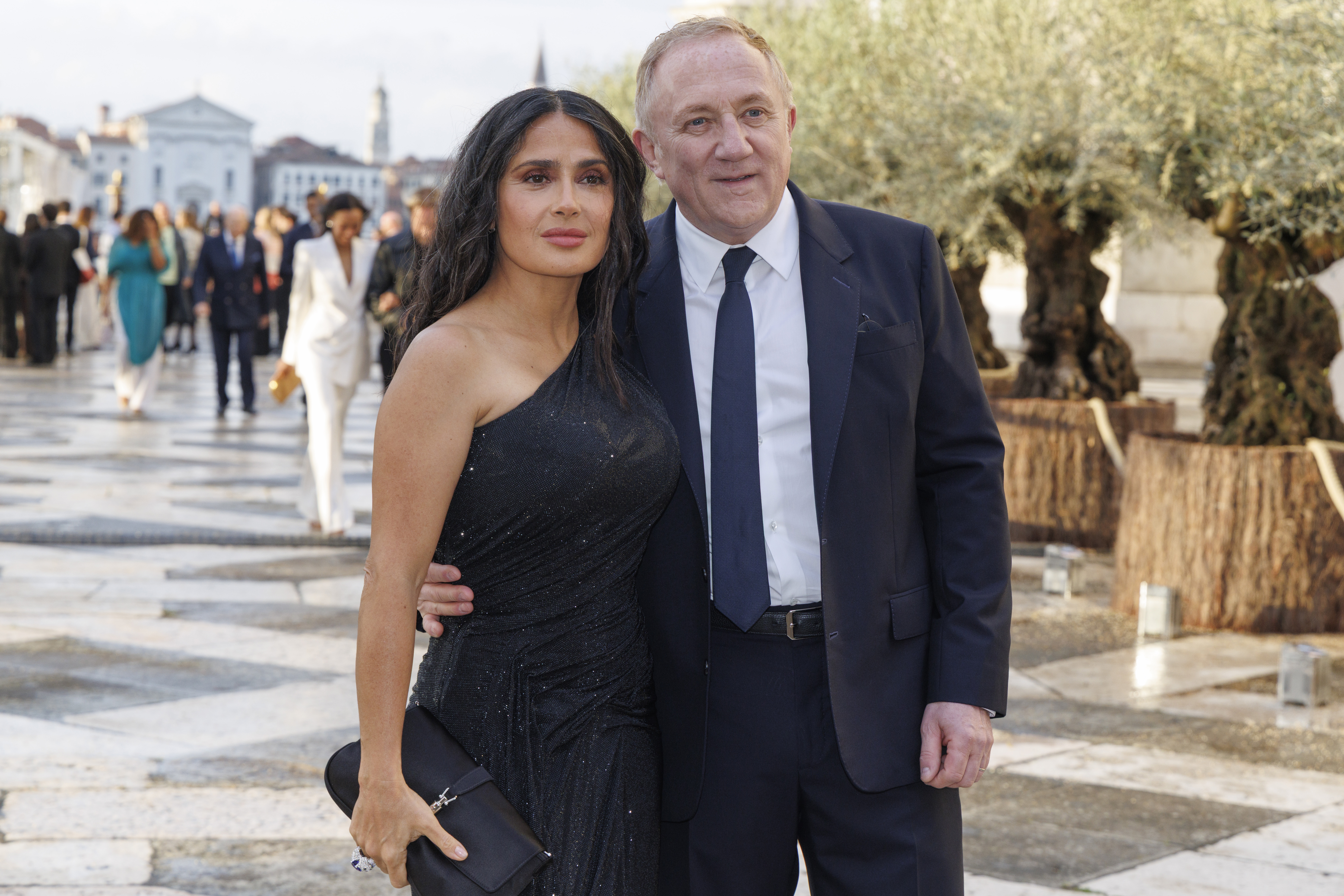 Salma Hayek in a black one-shoulder dress and François-Henri Pinault in a dark suit pose for a photo.
