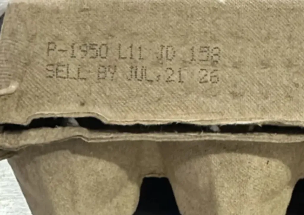 Close-up of a cardboard egg carton showing the printed code 