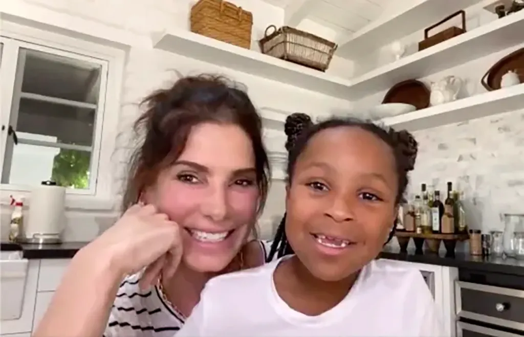 Sandra Bullock and her daughter Laila smiling at the camera.