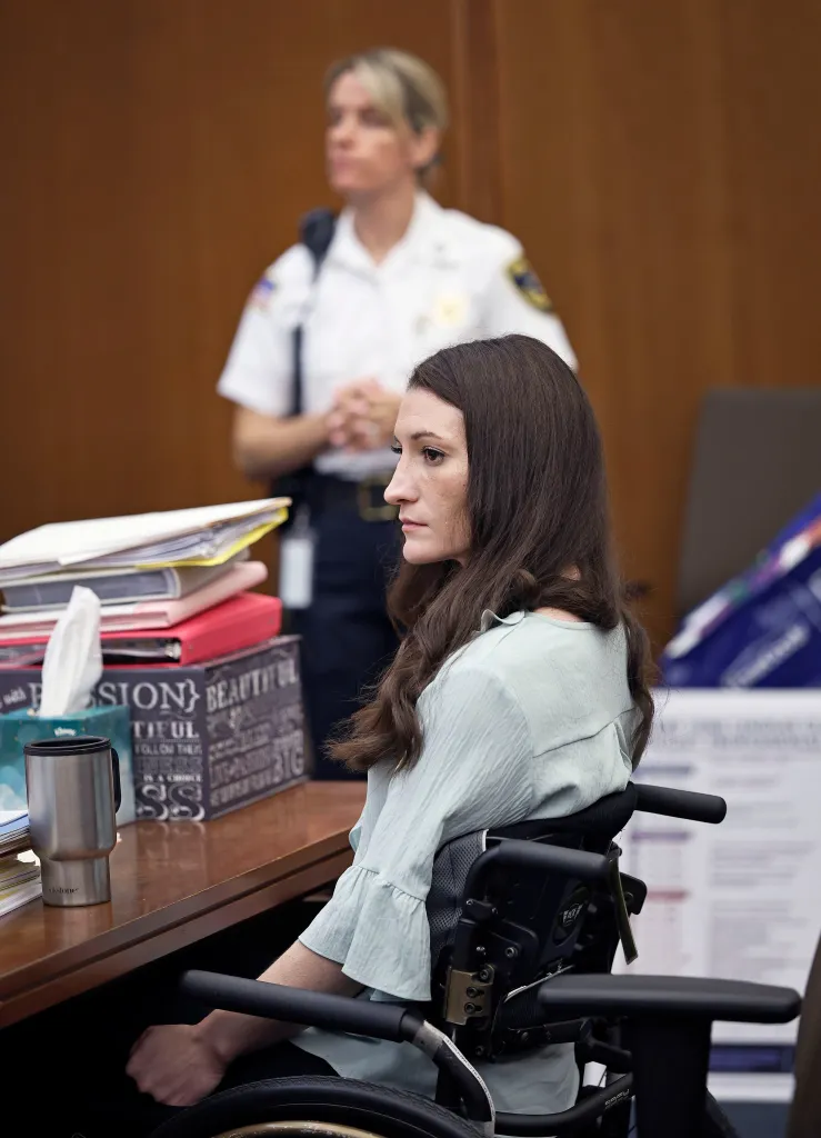 Lindsay Clancy listens to her attorney while sitting in a wheelchair during her court appearance.