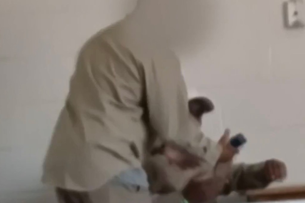 A person in a tan shirt inside a low-security correctional facility.