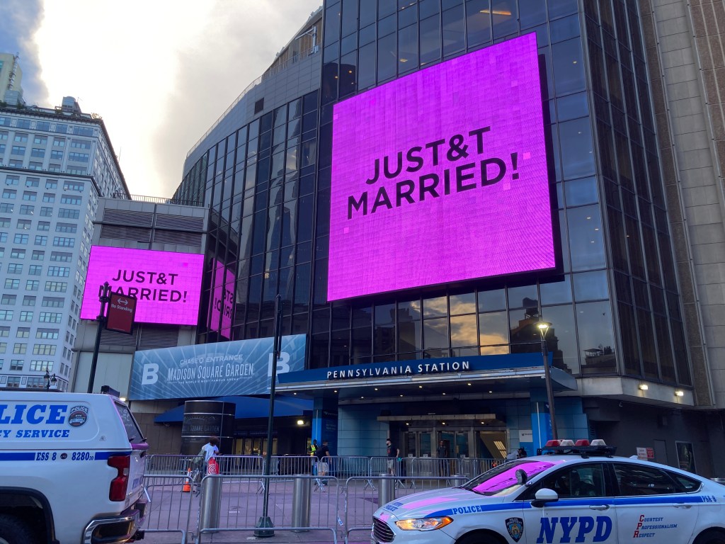Two large magenta billboards on Madison Square Garden display 