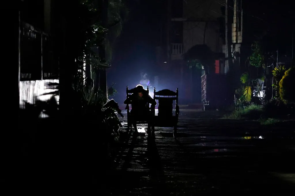 A person sits in an armchair during a blackout in Havana, Cuba as officials work on restoring electricity service across the country.