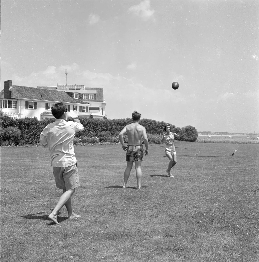 Senator John F. Kennedy and Jacqueline Bouvier playing football with Edward Kennedy.