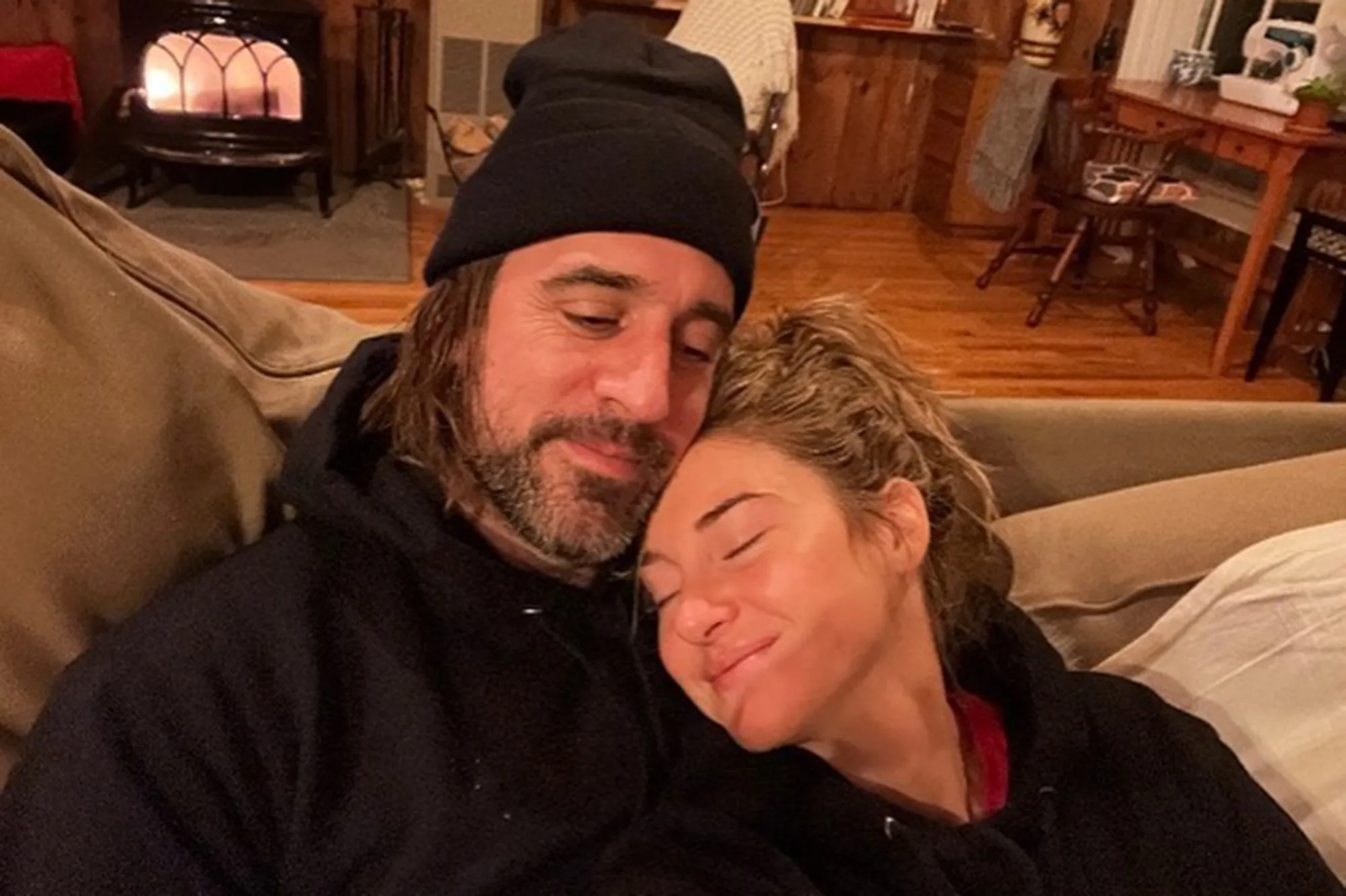Aaron Rodgers and Shailene Woodley relaxing on a couch.