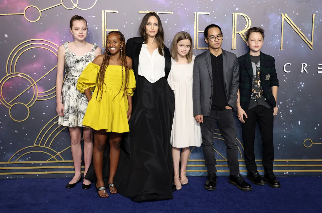 Angelina Jolie and her children Shiloh, Zahara, Vivienne, Maddox, and Knox Jolie-Pitt posing on a red carpet.