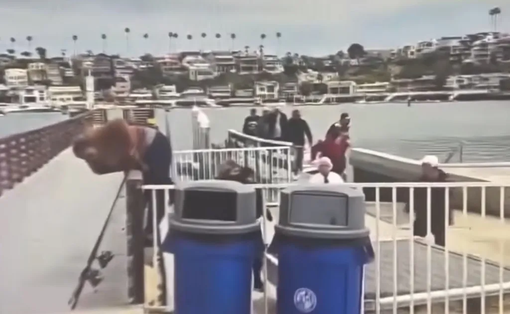 Migrants disembarking from a boat onto a pier in a California harbor.