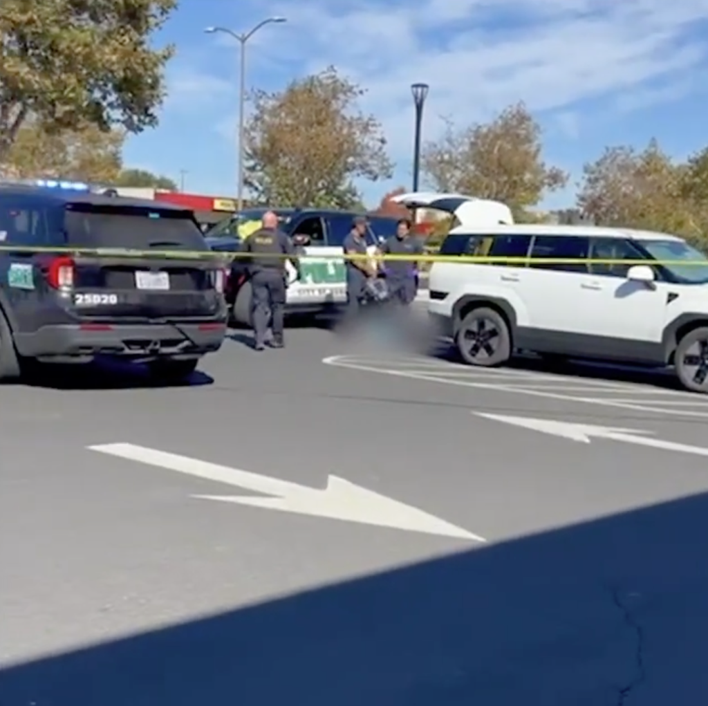Police vehicles and officers at the Dublin Sports Grounds parking lot, cordoned off by yellow tape.