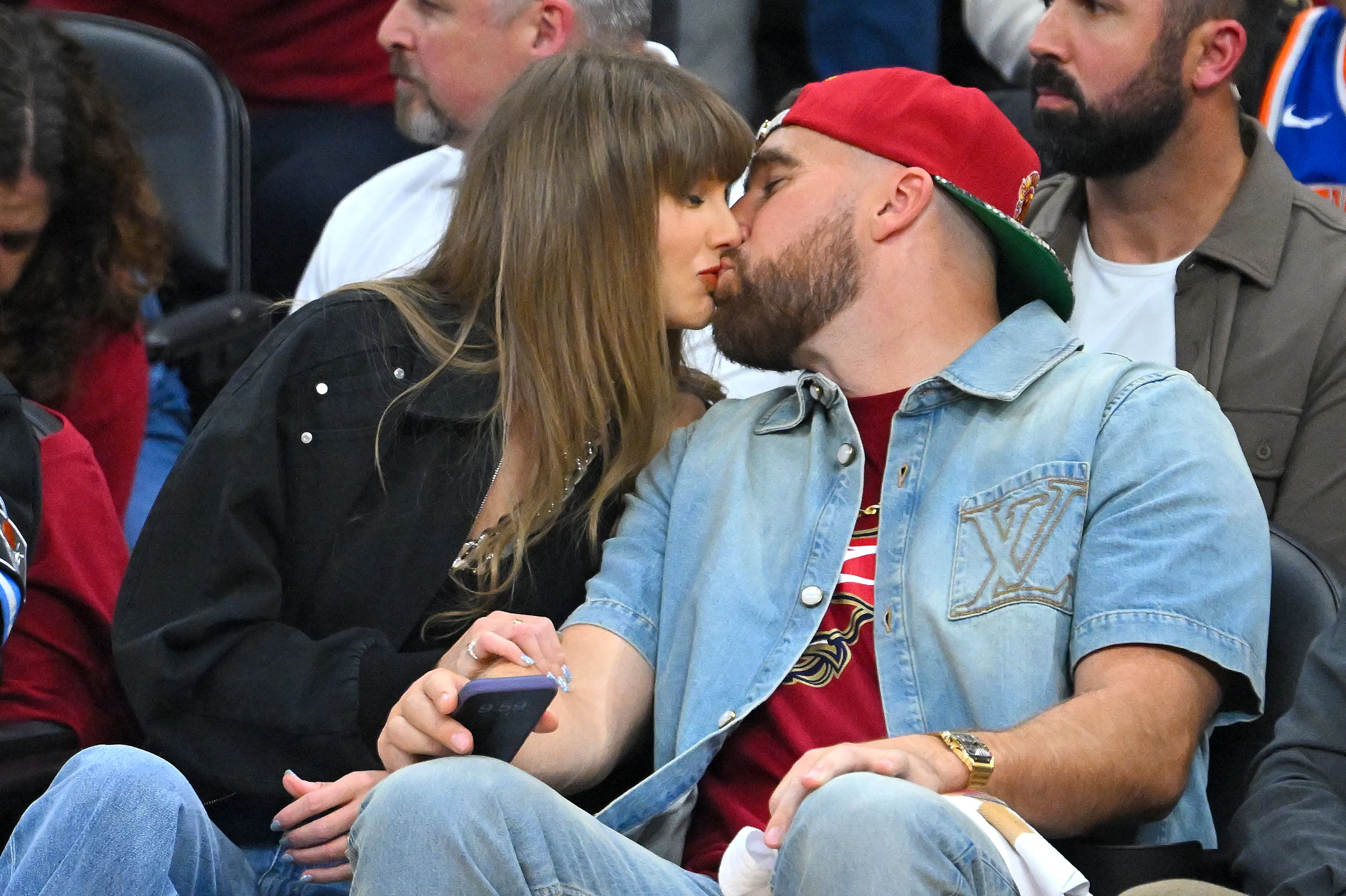 Singer Taylor Swift and Travis Kelce kissing.