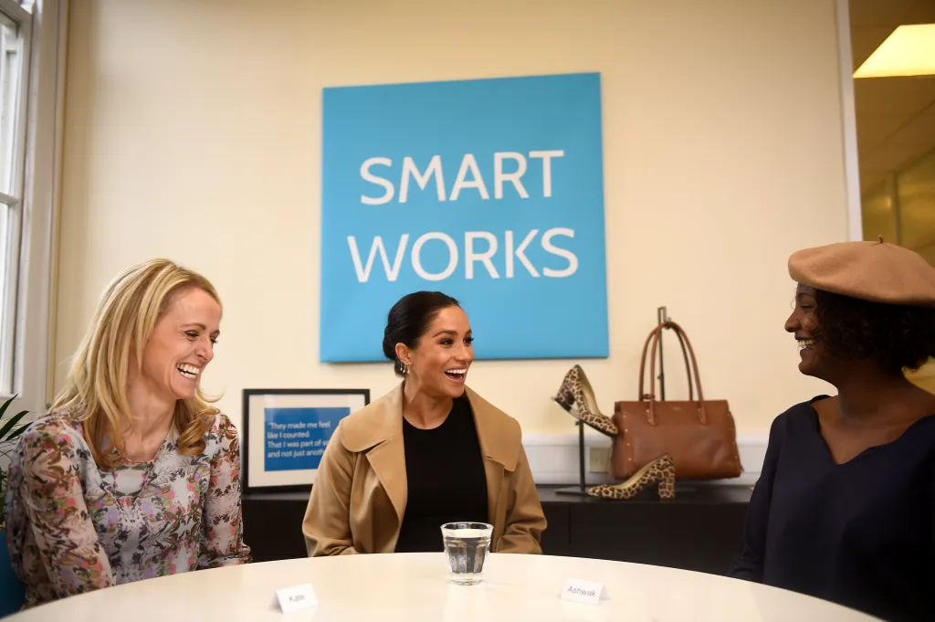 Meghan Markle and Smart Works CEO Kate Stephens, smiling and laughing during a visit.