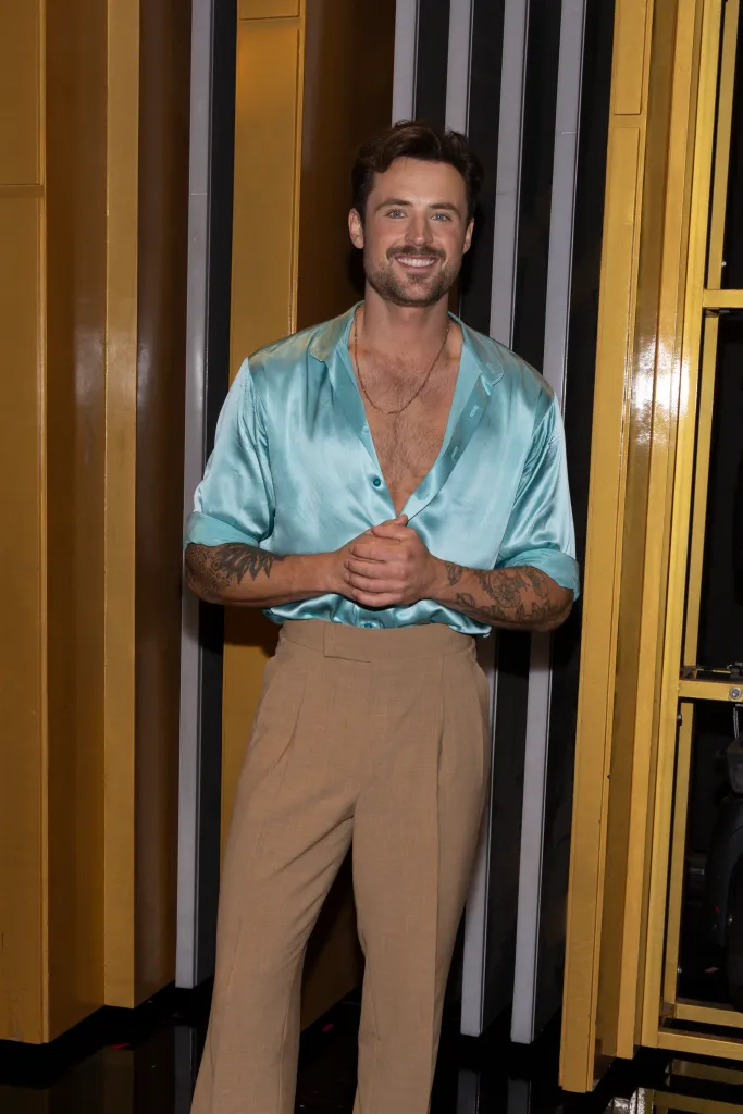 Dylan Efron standing and smiling at an event.