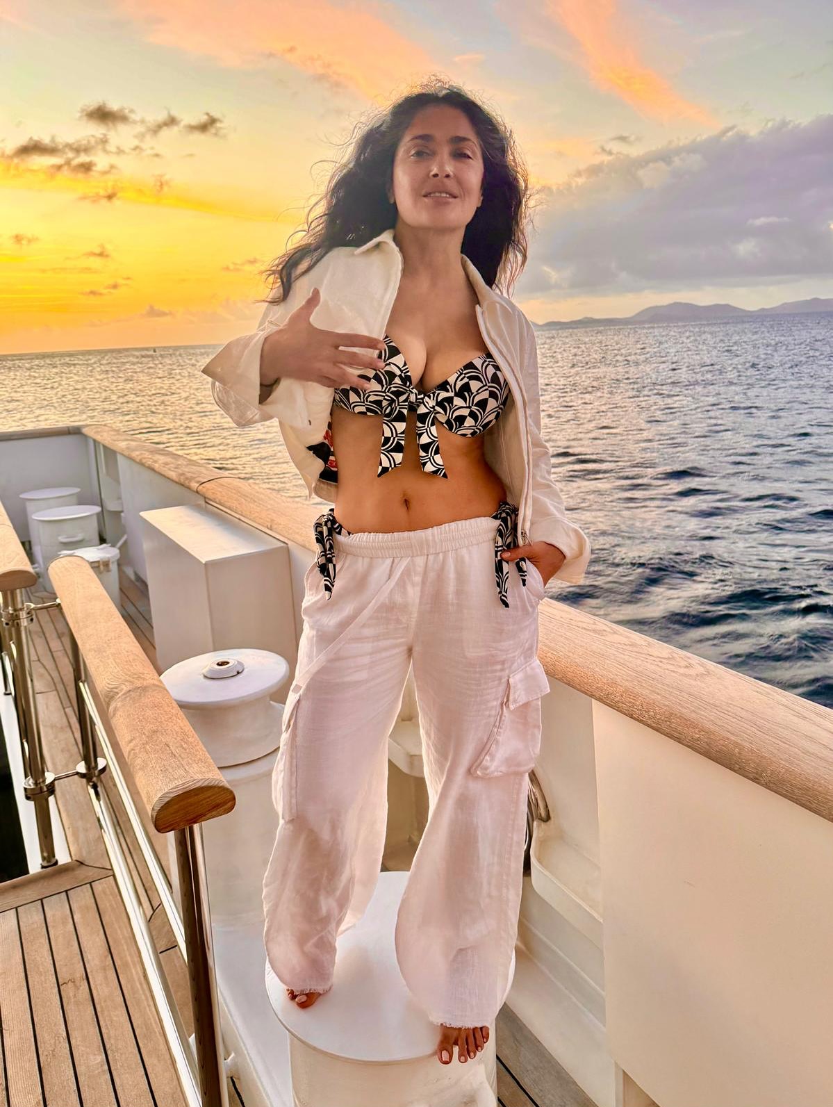 Salma Hayek posing on a boat at sunset.