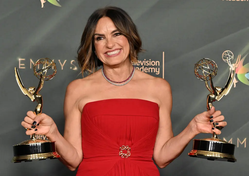 Mariska Hargitay holding two Emmy Awards.