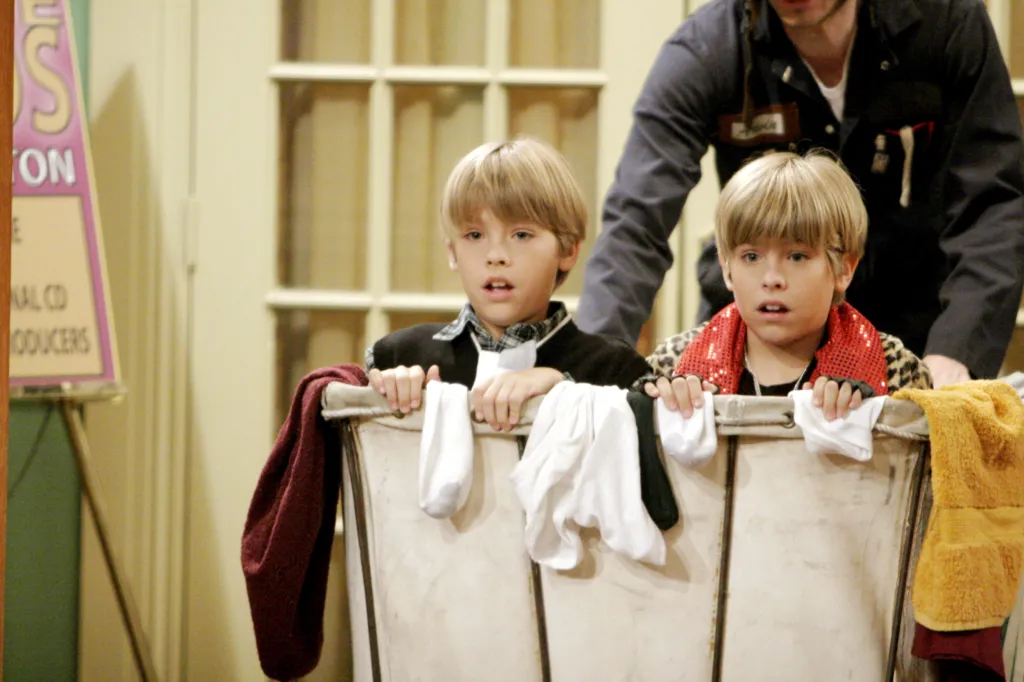 Identical twin brothers Dylan and Cole Sprouse hiding in a laundry basket.