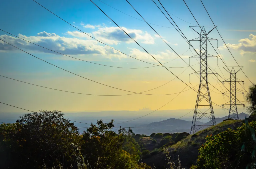 Sunset over the Los Angeles skyline with power lines in the foreground.